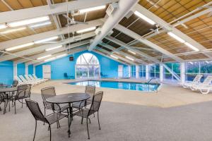 a pool room with tables and chairs and a swimming pool at Wingate by Wyndham Canton-Hall of Fame in Canton