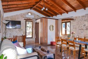 een woonkamer met een bank en een tafel bij Villa Anastasia Luxe with Top WiFi, BBQ & Amazing Views in Kissamos