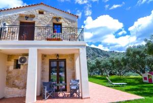 uma casa de pedra com uma varanda e um quintal em Villa Anastasia Luxe with Top WiFi, BBQ & Amazing Views em Kissamos