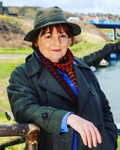 an older woman wearing a hat and a scarf at The Waterford Arms in Hartley