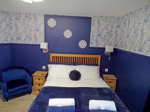 een blauwe slaapkamer met een bed en een blauwe muur bij Whinstone Holiday Home in Falkland in Falkland