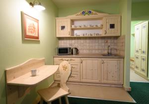 a kitchen with white cabinets and a table and chairs at Hotel Julianin dvor in Habovka