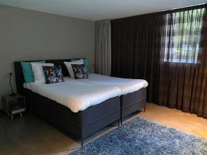 uma cama num quarto com uma grande janela em Bed & breakfast 23 em Amerongen