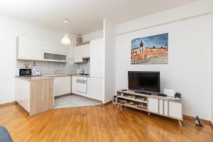a kitchen with white cabinets and a flat screen tv at APARTMAN RUPČIĆ in Vinkovci