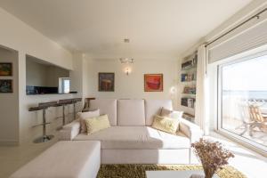 a living room with a white couch and a window at Fábrica da Ribeira 71 by Destination Algarve in Lagos