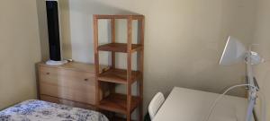 a room with a wooden book shelf next to a dresser at Habitacion individual en apartamento céntrico in Madrid