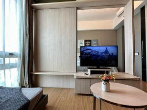 sala de estar con TV, cama y mesa en TheEden#13 SwissGardenKL, en Kuala Lumpur