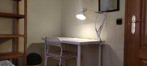 a room with a desk with a chair and a lamp at Habitacion individual en apartamento céntrico in Madrid