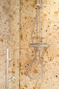 un cabezal de ducha en la pared del baño en Maison Victor en Koksijde