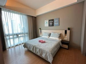 Un dormitorio con una cama con dos objetos rosados. en TheEden#13 SwissGardenKL, en Kuala Lumpur