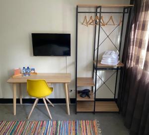 een bureau en een gele stoel in een kamer bij Bed & breakfast 23 in Amerongen