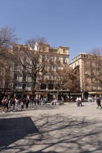 a group of people walking in a plaza in front of buildings at Suite Alhambra Puerta Bib-Rambla in Granada