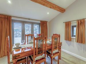 a dining room with a table and chairs and a window at Robcross Barn in Airton