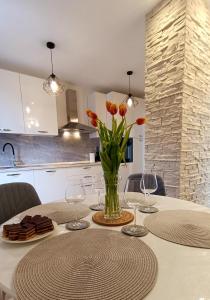 a dining room table with a vase of flowers on it at Apartman Leona in Lovran