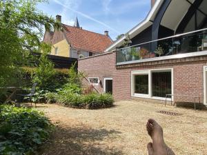 a person laying on the ground in front of a house at Bed & breakfast 23 in Amerongen