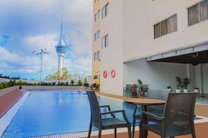 a pool with chairs and a table next to a building at Shahzan Hotel Kuantan, Trademark Collection by Wyndham in Kuantan