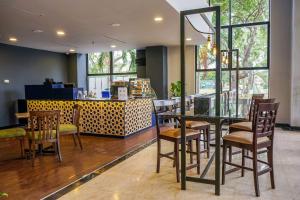 a restaurant with a table and chairs and a counter at Shahzan Hotel Kuantan, Trademark Collection by Wyndham in Kuantan