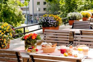 奧斯納布呂克的住宿－Vienna House by Wyndham Remarque Osnabrück，阳台上的野餐桌,摆放着食物和鲜花