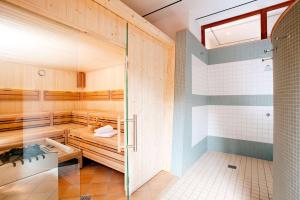 a sauna with a shower and a glass door at Vienna House by Wyndham Remarque Osnabrück in Osnabrück