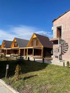 Casa de madera grande con porche y edificio en Riverside Eco Resort, en Debed