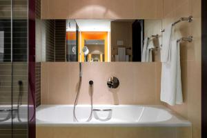 a bathroom with a shower and a bath tub at Vienna House by Wyndham Andel's Cracow in Krakow