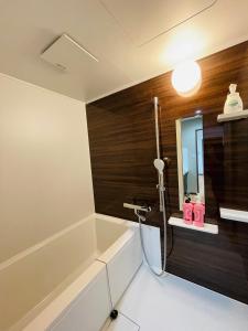 a bathroom with a bath tub and a sink at Uhome Kamogawa 本館-【ペット可/広い2LDK】 in Kamogawa