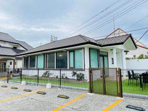 una casa con una valla delante de ella en Uhome Kamogawa 本館-【ペット可/広い2LDK】, en Kamogawa