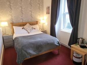 a bedroom with a bed and a window at Maridon House in Oban