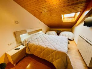 La Pobleta de BellveiにあるHotel Arturoの木製の天井のベッドルーム1室(ベッド2台付)