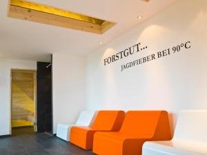 um sofá laranja e branco sentado numa sala em Forstgut Luxuschalets em Regen