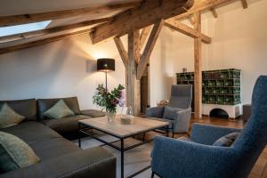 - un salon avec des canapés, des chaises et une table dans l'établissement Forstgut Luxuschalets, à Regen