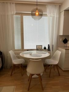 a table and chairs in a room with a window at Cozy Aparment with sauna nearby Airport in Vantaa