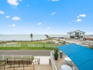 a blue umbrella sitting on a balcony overlooking the beach at LR 205 - La Las in Rockport