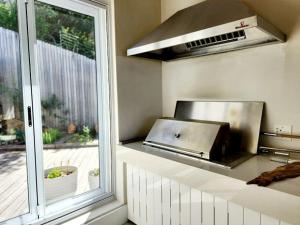 a kitchen with a grill on a counter next to a window at Contemporary villa with amazing views in Plettenberg Bay