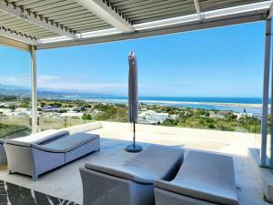 una sala de estar con sofás y vistas al océano. en Contemporary villa with amazing views, en Plettenberg Bay