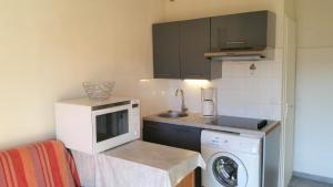 a small kitchen with a washing machine and a microwave at Résidence Cap Azur Appartement 108 in Villeneuve-Loubet