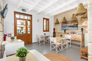 a restaurant with white walls and tables and chairs at Hotel Boutique Ses 5 Claus in Ciutadella