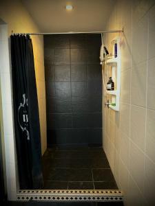 a shower with a black shower curtain in a bathroom at 84 Gallery in Chiang Mai