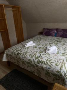 a bedroom with a bed with towels on it at Spēlmaņu krogs in Alsunga