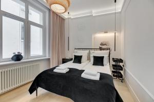 a white bedroom with a large bed with pillows at Sopot Monte Cassino by Downtown Apartments in Sopot