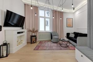 a living room with a couch and a tv at Sopot Monte Cassino by Downtown Apartments in Sopot