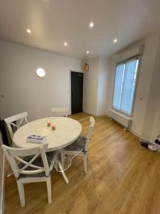 d'une salle à manger avec une table, des chaises et une fenêtre. dans l'établissement Paris Centre CLAMART Hôpital PERCY APPART 2 pièces TRÈS Lumineux Grand, à Clamart