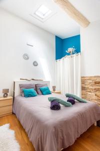 昂蒂布的住宿－Cosy apt for 6/8p best location in old Antibes，一间卧室配有一张大床,提供紫色和蓝色枕头