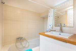 W łazience znajduje się umywalka, wanna i lustro. w obiekcie Cosy apt for 6/8p best location in old Antibes w mieście Antibes