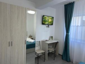 Cette chambre comprend un bureau, un lit et une table. dans l'établissement Casa Dramar, à Techirghiol