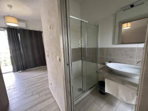 a bathroom with a sink and a glass shower at Frontemare Hotel Village & Ristorante in Rodi Garganico