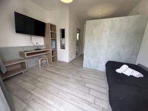 a living room with a bed and a television in it at Frontemare Hotel Village & Ristorante in Rodi Garganico