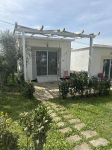a white house with a pergola in a yard at Frontemare Hotel Village & Ristorante in Rodi Garganico