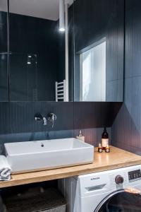 a bathroom with a sink and a washing machine at Kowalska no 4 Apartment in Gdańsk