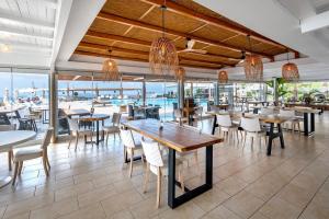a restaurant with tables and chairs and a pool at Smy Santorini Suites & Villas in Pyrgos